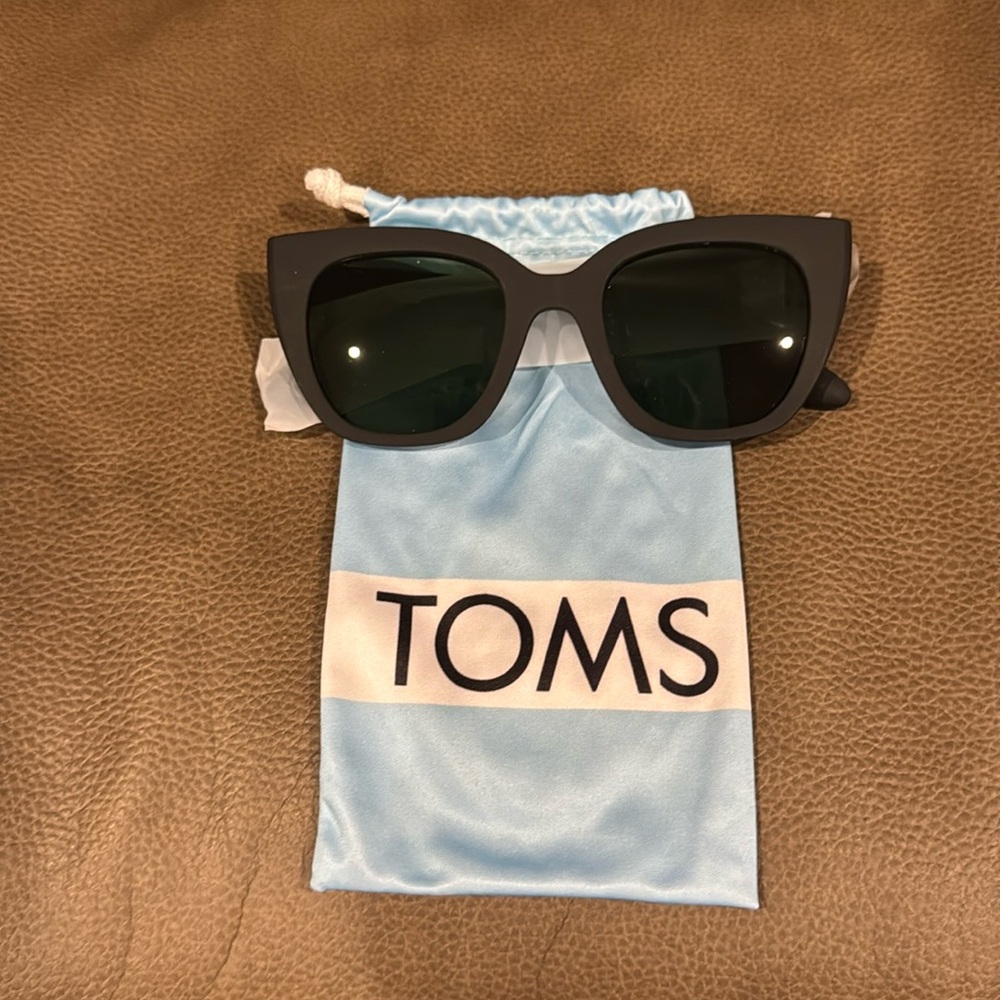 Tom’s new matte black sunglasses with storage bag and drawstring close.